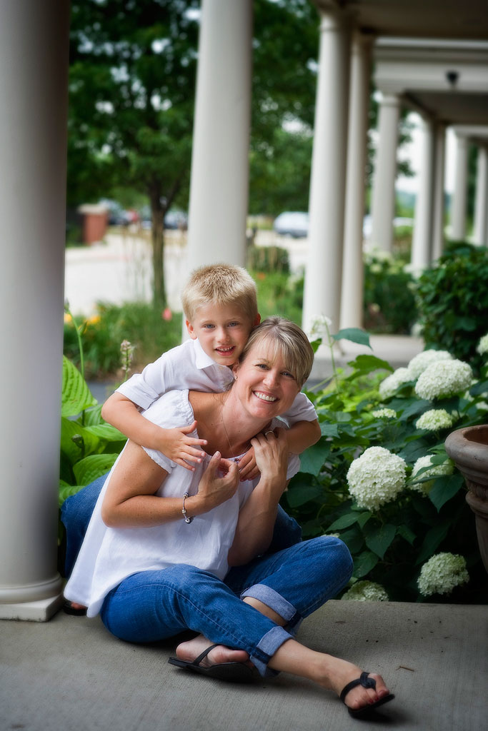 A young boy and his mom on their flower filled front porch in North Shore Chicagoland by Marmalade Photography